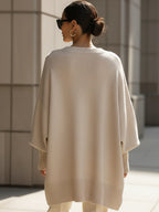 Oversized knit sweater, side view showing the loose drape at the arms