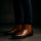 Pair of men's Chelsea boots shown from the side and back, with elastic gusset visible
