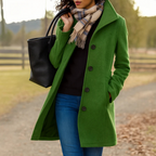 Long coat for women worn buttoned over a sweater, showing the straight knee-length cut
