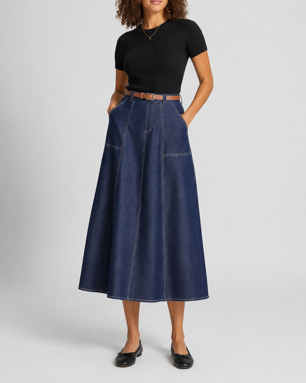Navy pleated A-line skirt worn with a knit top, side view of the A-line shape
