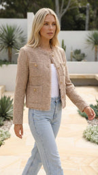 The beige cropped jacket photographed mid-stride