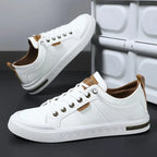 Men's leather sneakers in white and brown, angled view showing the stitched side panels