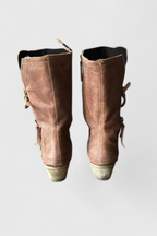 Detail of the diagonal zip running through the cuff of the brown leather boot