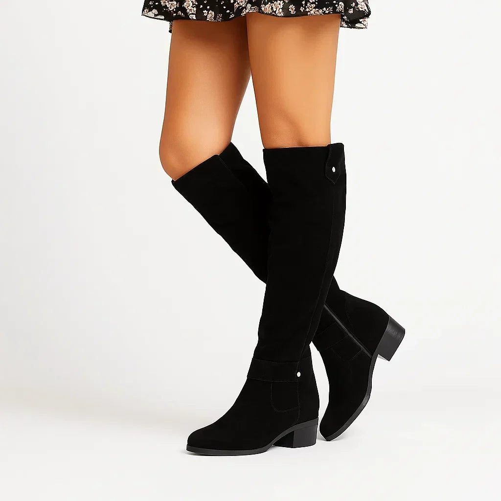 Black suede boot photographed from the inner side where the zip runs