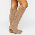 Beige suede boot standing upright, shaft rising to just under the knee