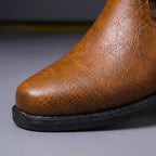 Close look at the boot's polished metal eyelets and stitching