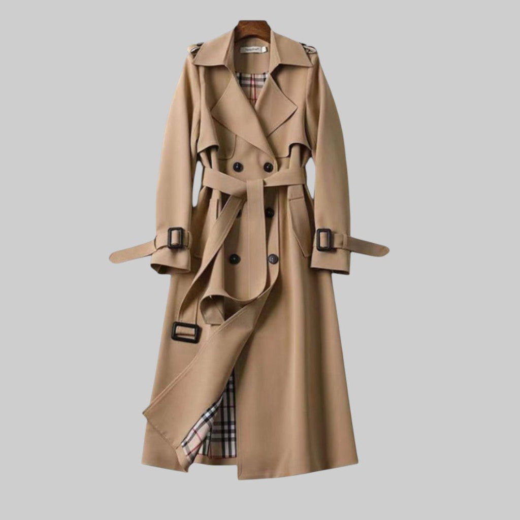 Beige trench coat belted at the waist, falling to midi length