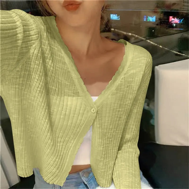 Green ribbed knit cardigan with the sleeves pushed up